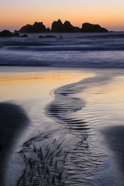 USA, Oregon, Bandon. Water flows into ocean at low tide on Bandon Beach. Credit as