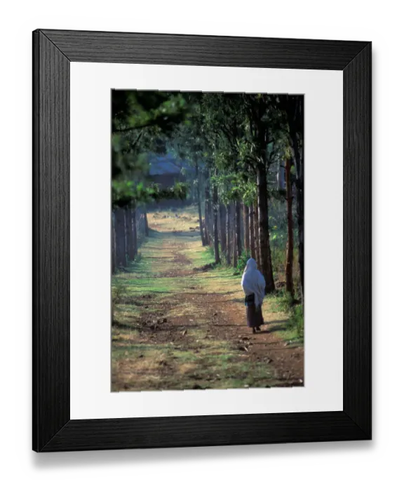 Framed Print : A Konso villager walks down a dirt road that leads to a small Konso village, in