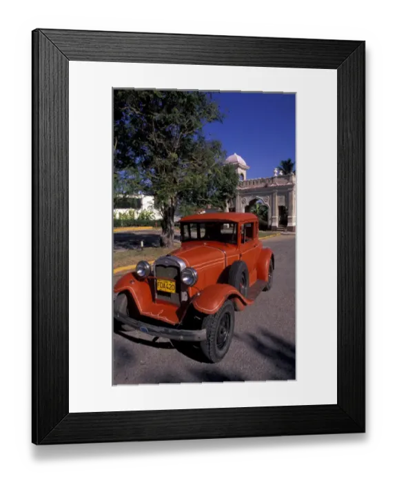 Framed Print : Cuba, Cien Fuergos, Old Model A Ford and colorful architecture behind