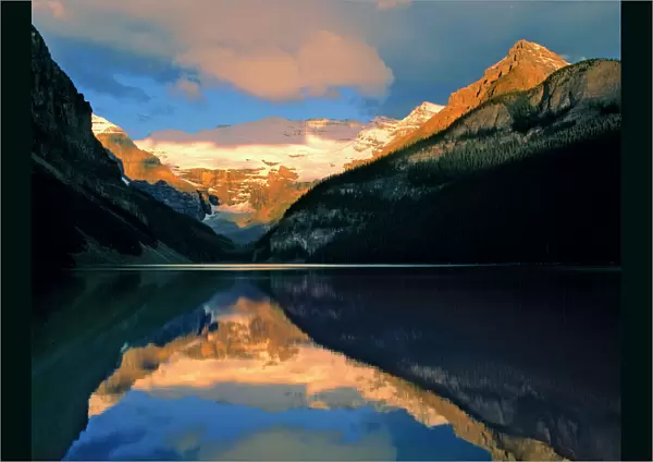 Canada, Alberta, Lake Louise. Sunrise brightens the still waters of Lake Louise, Banff NP