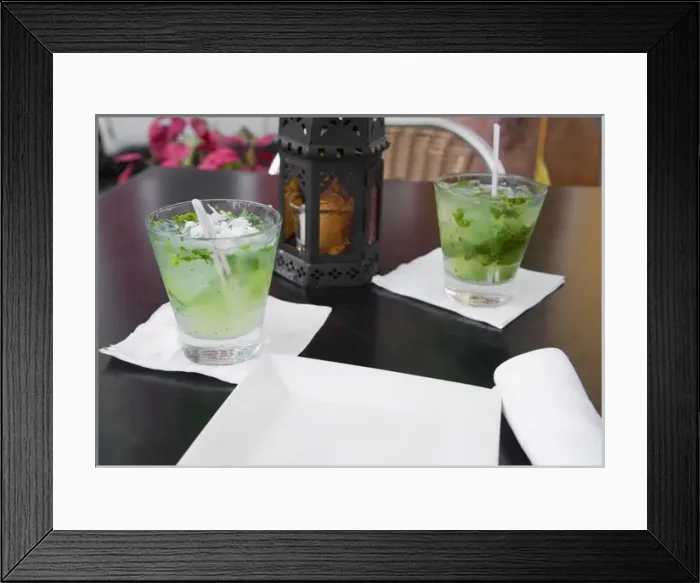 Framed Print : San Juan, Puerto Rico - Two alcoholic beverages are sitting on a table next to a lantern