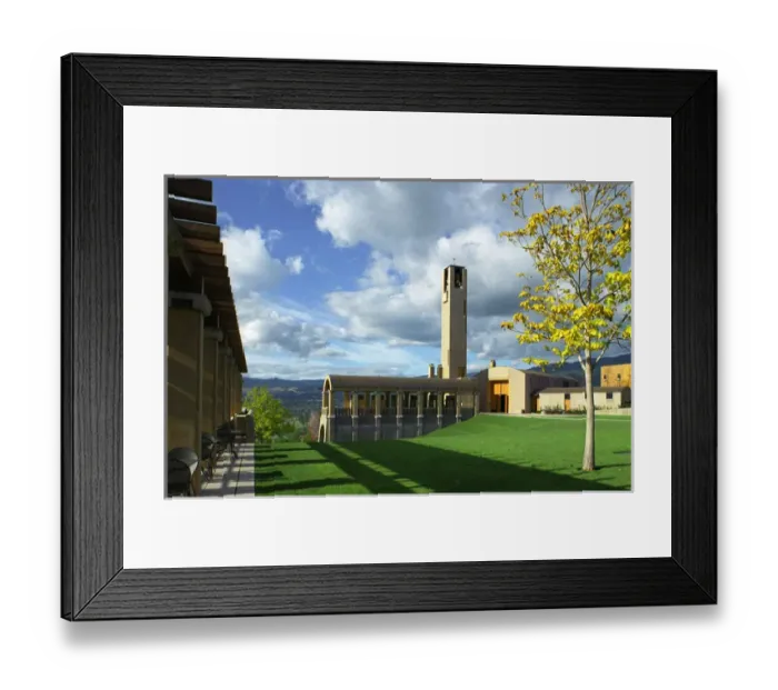Framed Print : The concrete bell tower seems to touch the clouds in a blue sky over the architecturally