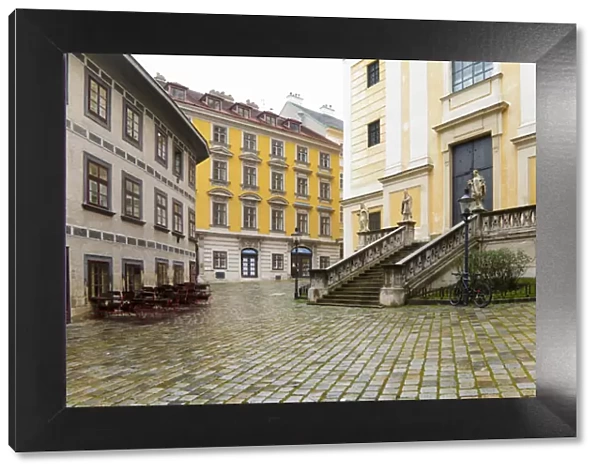 Vienna, Austria - A cobblestone town square surrounded by old world buildings. Horizontal