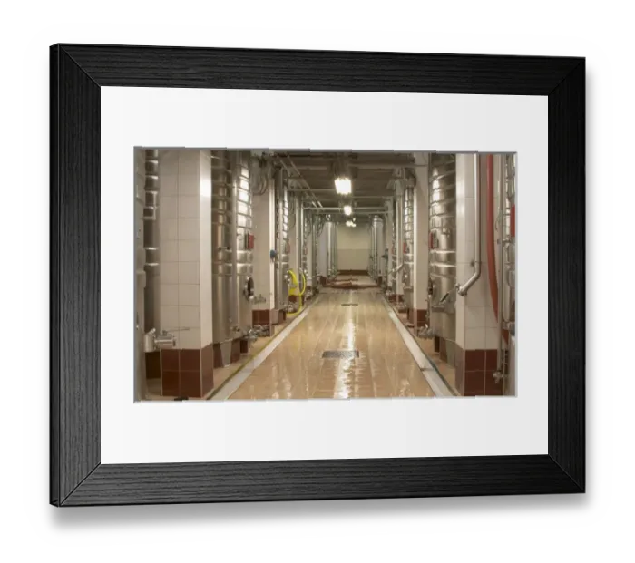 Framed Print : Rows of stainless steel fermentation tanks and a newly cleaned floor. The winery is designed Framed Print : Rows of stainless steel fermentation tanks and a newly cleaned floor. The winery is designed