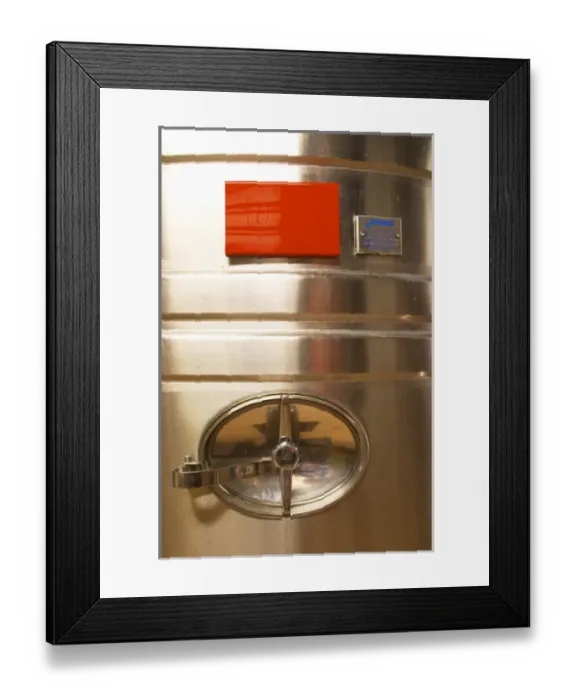 Framed Print : A detail of a stainless steel wine fermentation tank with the opening. The winery is designed