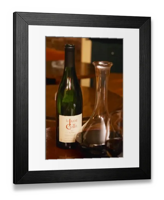 Framed Print : Bottle on a table with wine glasses and decanter in the wine bar Le Cafe du Passage in Paris