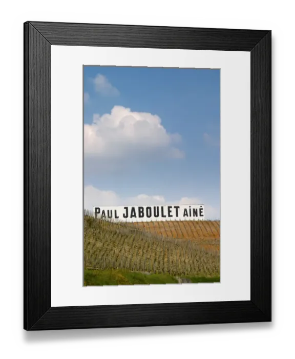 Framed Print : A big white sign with black letters Paul Jaboulet Aine against a blue sky, in front