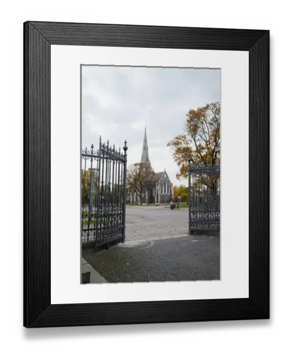 Framed Print : Copenhagen, Denmark - Open wrought iron gates leading to the cobblestone courtyard of a church