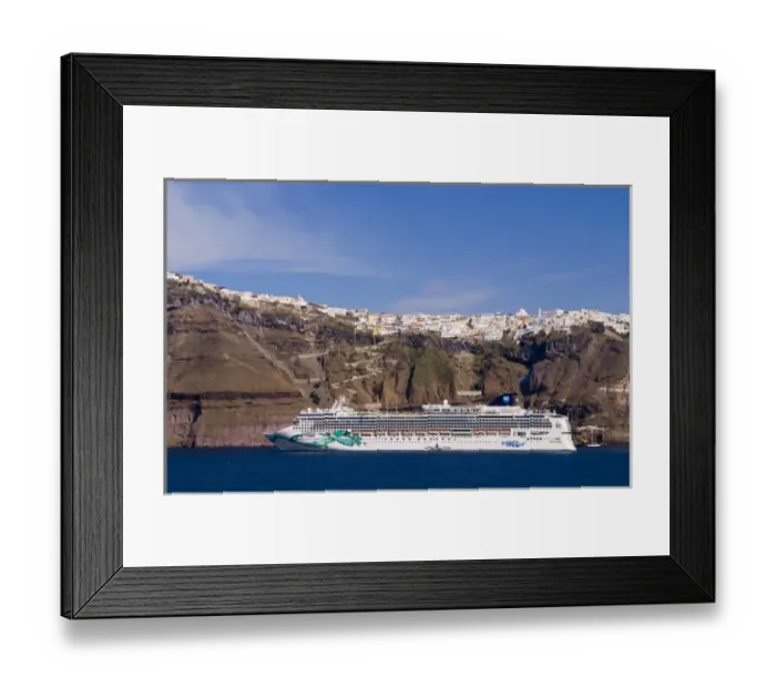 Framed Print : The beautiful buildings on the mountain cliffs and the cruise ship are docked at Santorini Framed Print : The beautiful buildings on the mountain cliffs and the cruise ship are docked at Santorini
