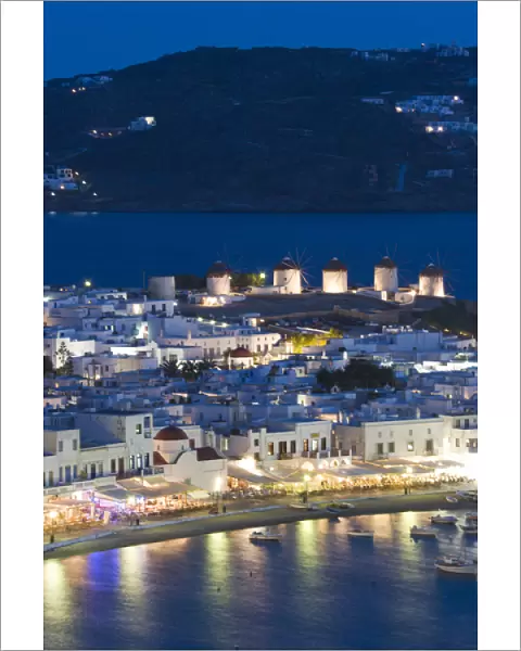 Europe, Greece, Mykonos, Hora. Night view overlooking harbor with illuminated windmills