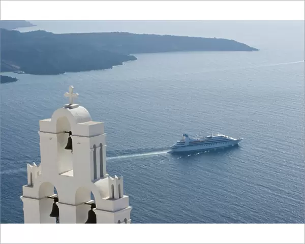 Europe, Greece, Santorini. Blue church dome and white bell tower overlooking a luxury yacht