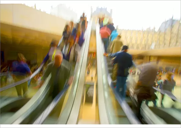 France, Paris. The Louvre. Escalator and tourists in the modern glass pyramid. Credit as