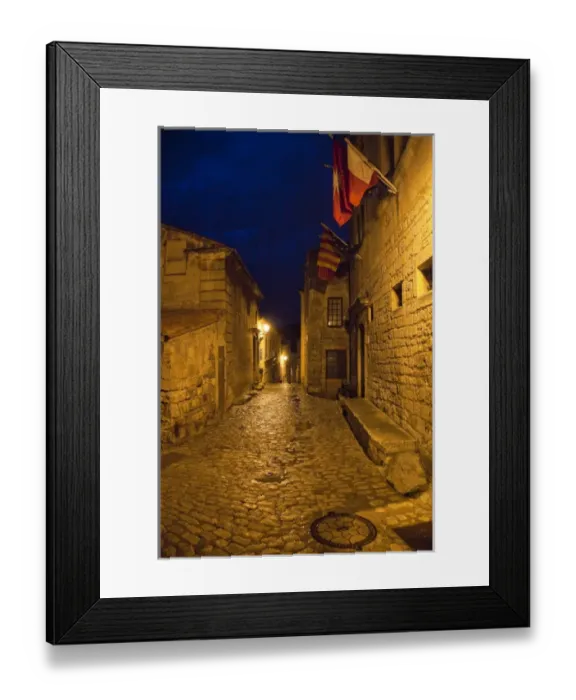 Framed Print : France, Provence, Les Baux-de-Provence. Flags over deserted street inside castle at night Framed Print : France, Provence, Les Baux-de-Provence. Flags over deserted street inside castle at night