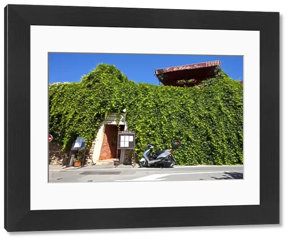 France, Provence, Roussillon. Motorcycle outside restaurant entrance. Credit as