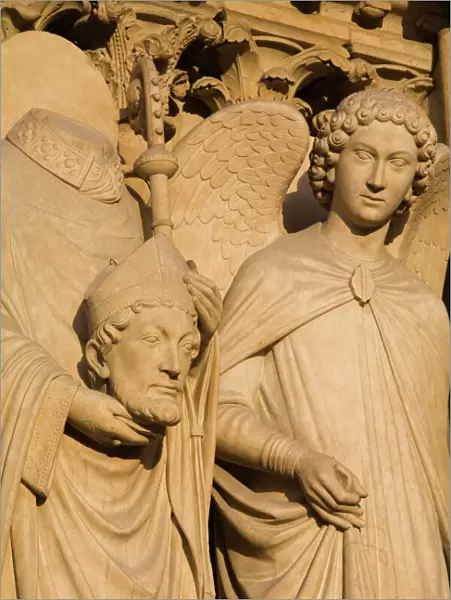 Sculpture on facade of Notre Dame Cathedral of Saint Denis after his martyrdom by decapitation