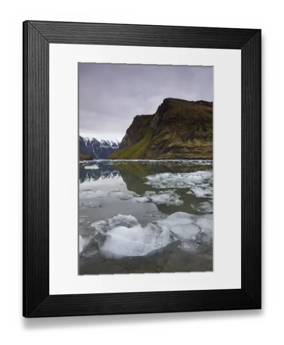 Framed Print : Norway, Svalbard, Spitsbergen, Small icebergs floating in fjord beneath mountain
