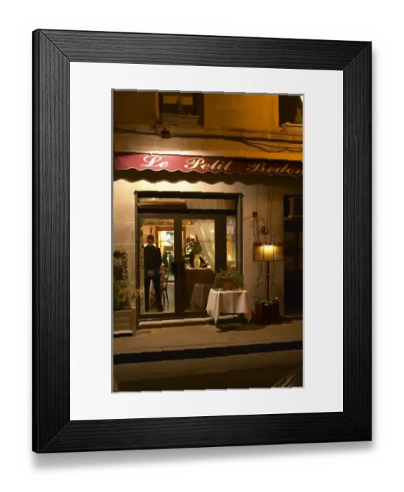 Framed Print : The restaurant Le Petit Bedon at night with the waiter standing inside the door. Avignon