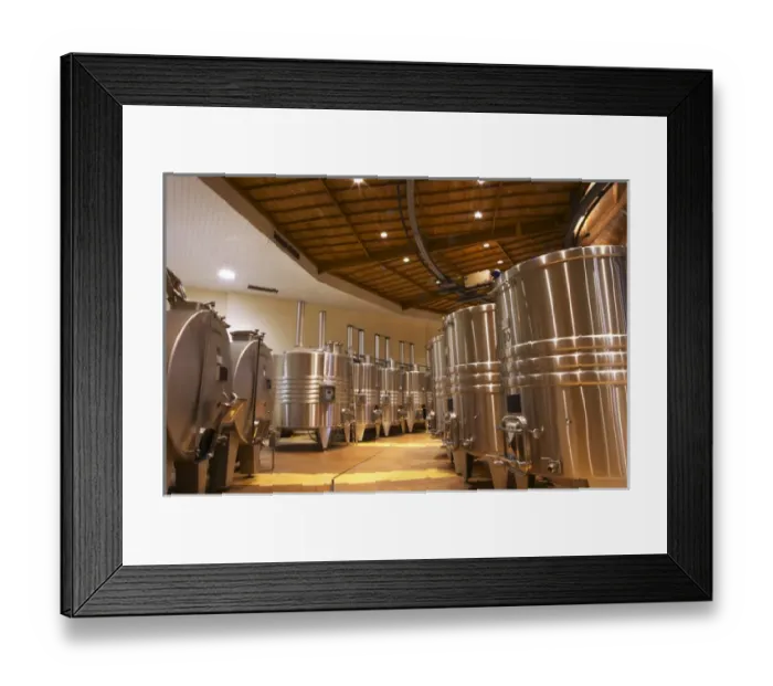 Framed Print : The winery with wooden and stainless steel fermentation vats. It is built in a circular design
