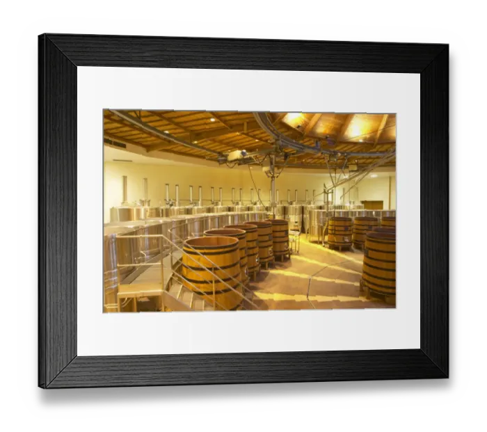 Framed Print : The winery with wooden and stainless steel fermentation vats. It is built in a circular design