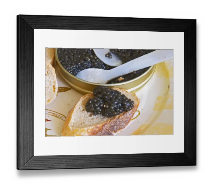 Framed Print : A tin of black caviar with slices of bread and a spoon of mother-of-pearl to scoop