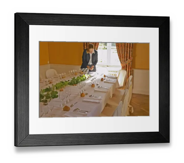 Framed Print : The table set for lunch and wine tasting for visitors and a watress at a sunny window