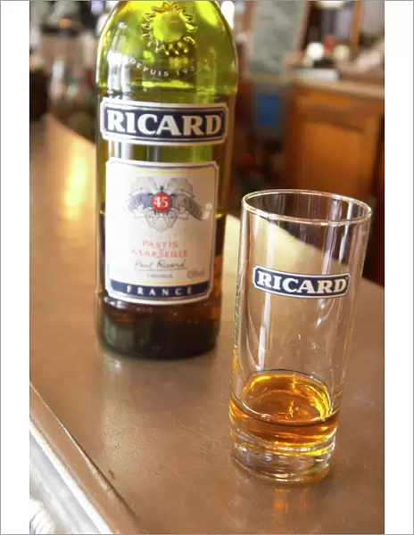 A bottle of Ricard 45 pastis and a glass on a zinc bar in a cafe bar in Paris Pastis