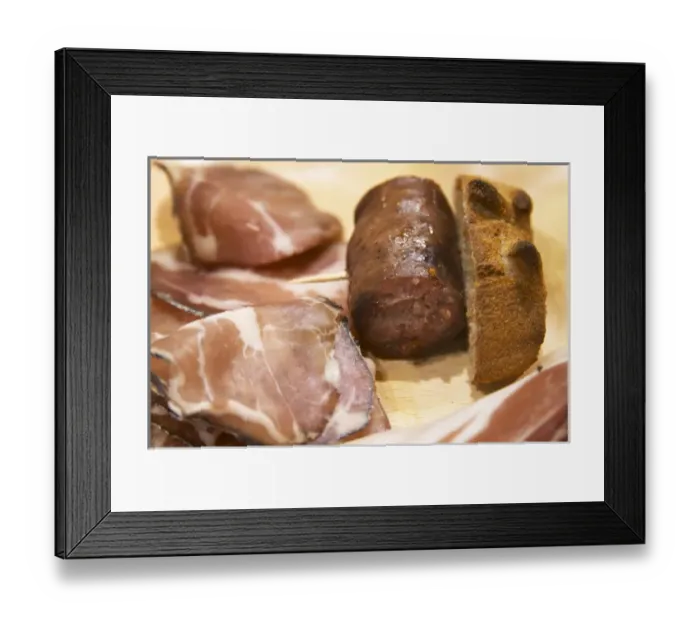Framed Print : Corsica style charcuteries, smoked and dried ham, sausages on a wooden cutting board