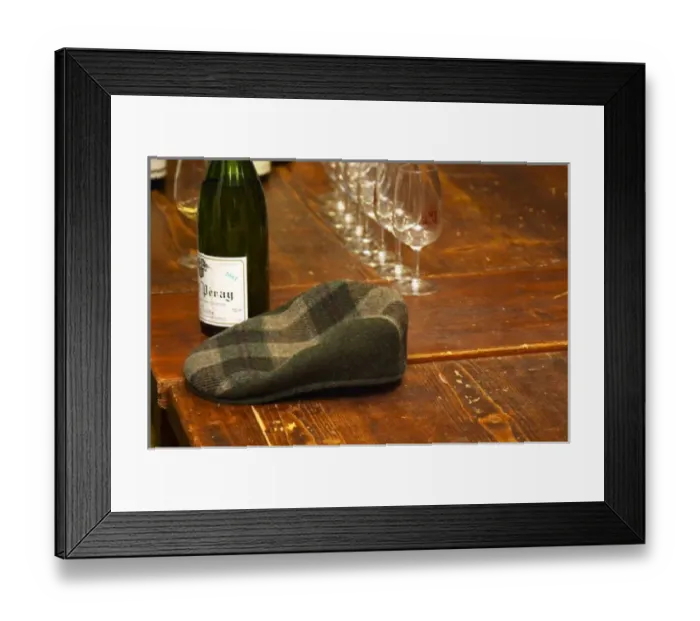 Framed Print : The emblematic cap of Alain Voge on a wooden table and some wine glasses and bottles