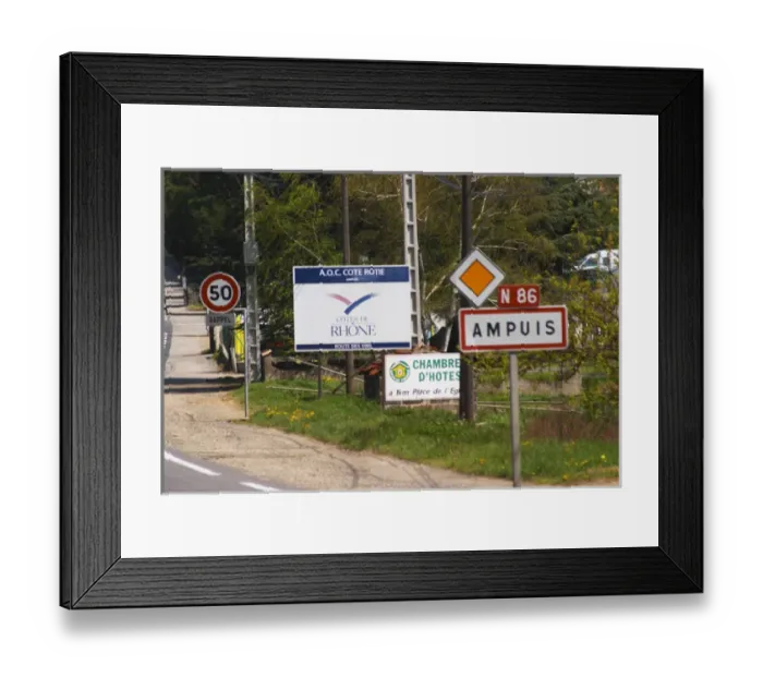 Framed Print : The entrance to Ampuis with road signs with the name of the town and a big sign saying
