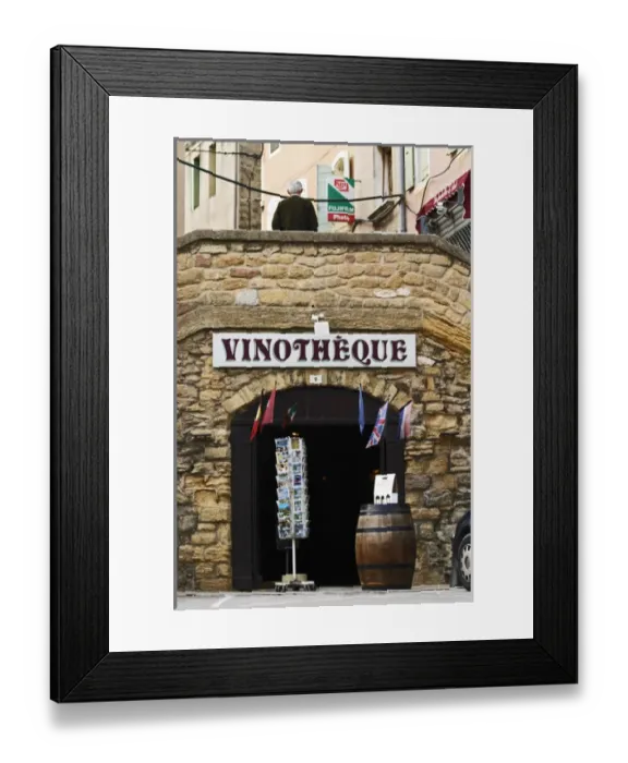 Framed Print : A wine shop vinotheque with flags, post cards on a stand and a barrel with wine bottles Framed Print : A wine shop vinotheque with flags, post cards on a stand and a barrel with wine bottles