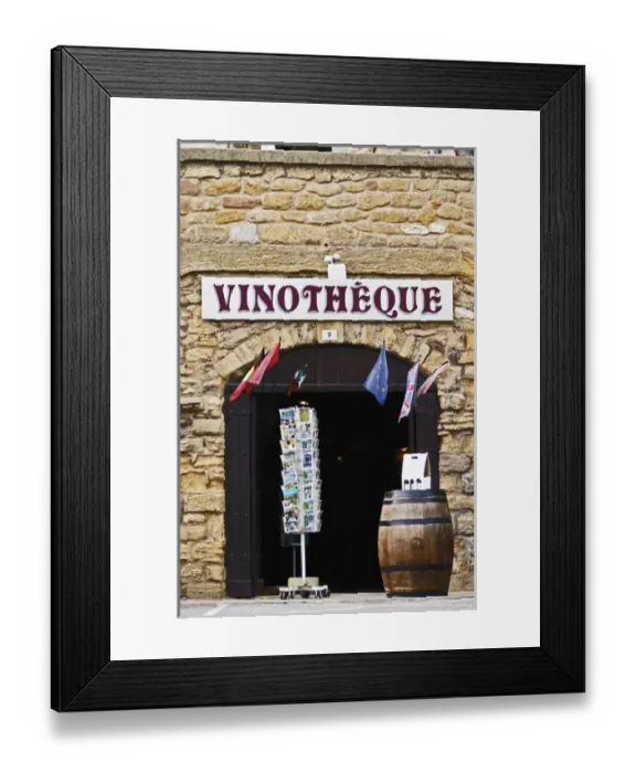 Framed Print : A wine shop vinotheque with flags, post cards on a stand and a barrel with wine bottles Framed Print : A wine shop vinotheque with flags, post cards on a stand and a barrel with wine bottles