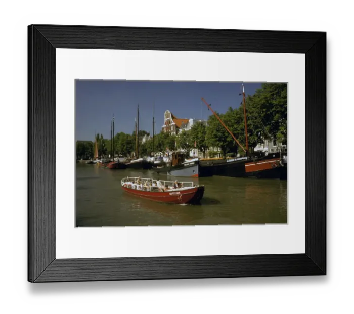 Framed Print : Europe, Netherlands, Dordrecht. Boats lining canal, with tourist boat motoring by