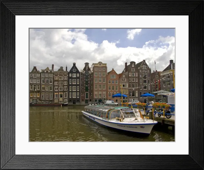 Framed Print : A tour boat at Rederij Plas dock on a canal lined with colorful gabled homes