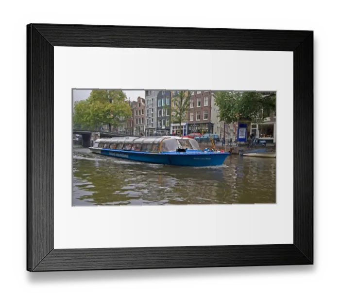 Framed Print : A tour boat full of people travel a canal lined with colorful gabled homes Framed Print : A tour boat full of people travel a canal lined with colorful gabled homes