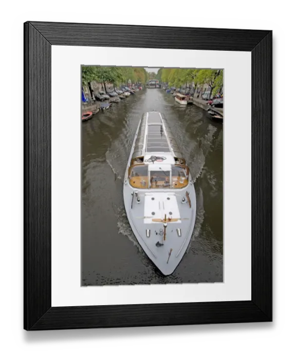 Framed Print : A long glass topped tour boattravels down a boat lined canal Framed Print : A long glass topped tour boattravels down a boat lined canal