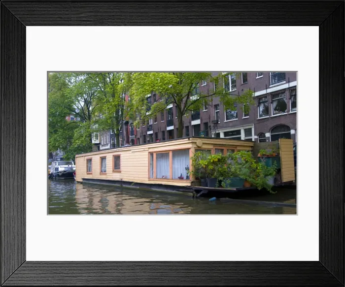 Framed Print : A colorful peach houseboat on a tree lined canal