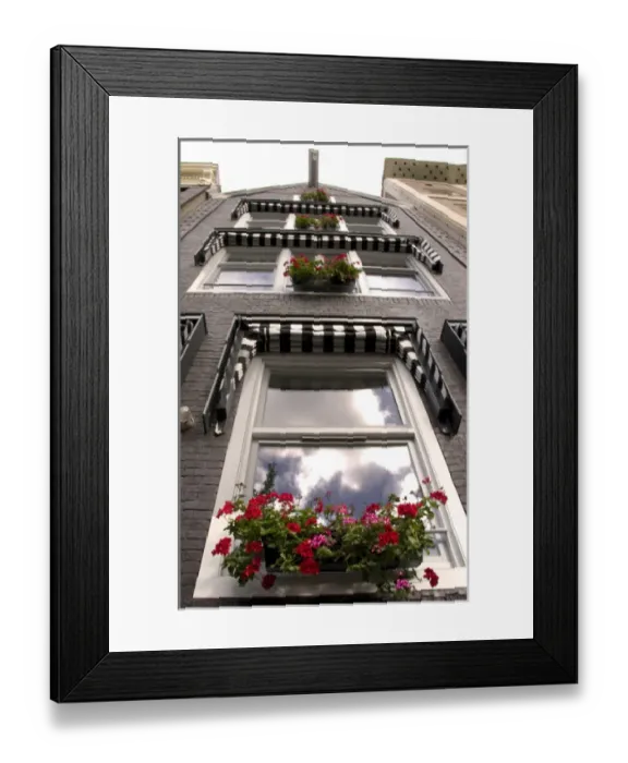 Framed Print : Clouds reflected in windows looking up a building with window boxes of red flowers Framed Print : Clouds reflected in windows looking up a building with window boxes of red flowers