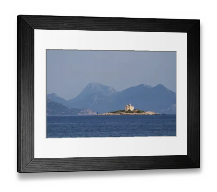 Framed Print : A lighthouse light house on an island outside the village, blue mountains in the background Framed Print : A lighthouse light house on an island outside the village, blue mountains in the background