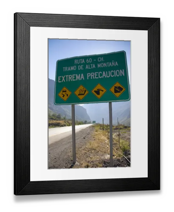 Framed Print : Spanish language road sign warning of hazardous road conditions at the foot of Framed Print : Spanish language road sign warning of hazardous road conditions at the foot of