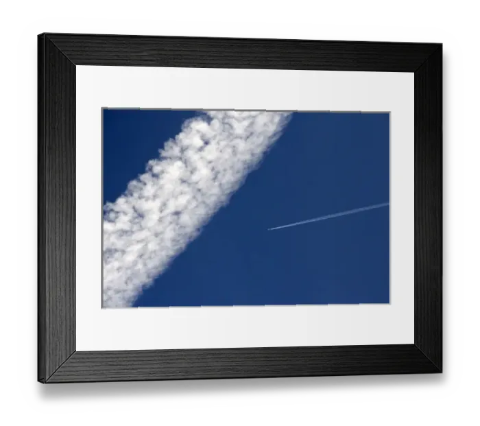 Framed Print : Vapor contrails from high flying jet aircraft. The larger has been blown apart by