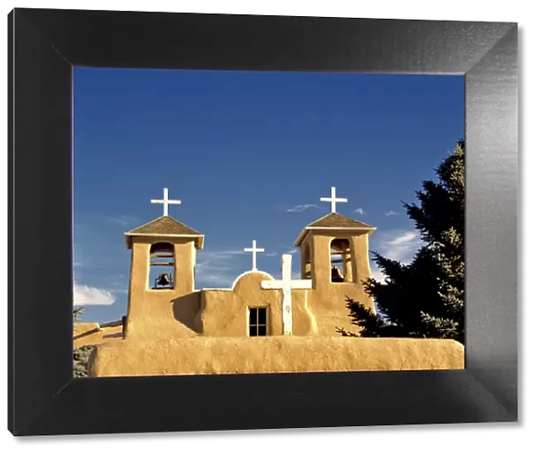 USA, New Mexico, Taos. Simple white crosses top the bell towers of St. Francis de Assisi Church