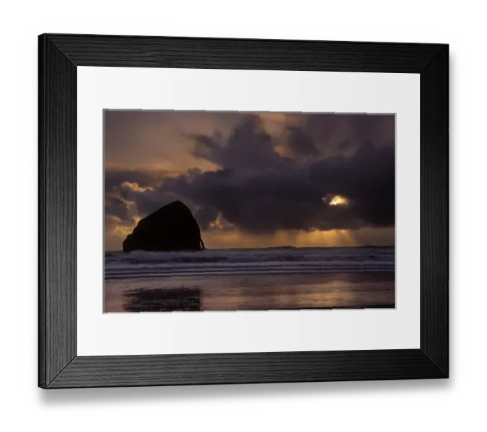 Framed Print : Sunset colors the skies as the sun sets behind clouds near on the horizon at Cape Kiwanda