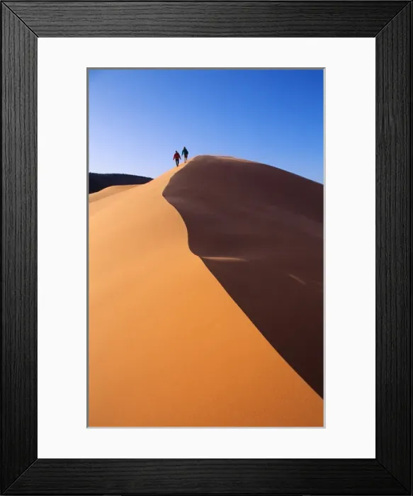 Framed Print : A couple walks along the crest of a golden sand dune in Coral Pink Sand Dunes State Park Framed Print : A couple walks along the crest of a golden sand dune in Coral Pink Sand Dunes State Park