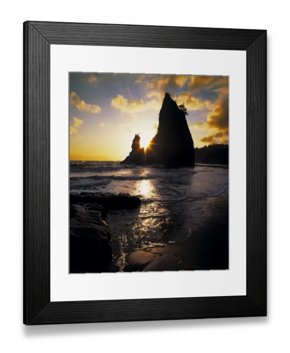 Framed Print : A seastack juts skyward with the setting suns rays streaking through a cleft in the rock Framed Print : A seastack juts skyward with the setting suns rays streaking through a cleft in the rock