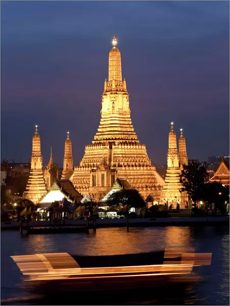 Temple of Dawn (Wat Arun) at dusk with boat on Chao Phraya River, Bangkok, Thailand