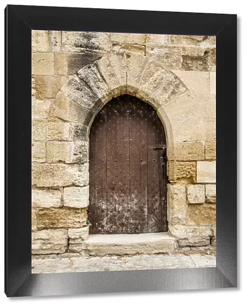 french medieval arched door in stone wall