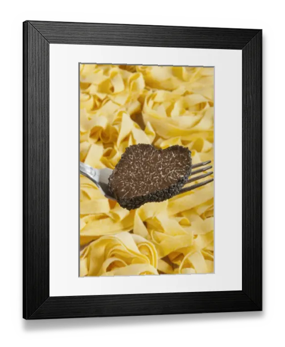 Framed Print : Summer black truffle (Tuber aestivum) on a fork with pasta background