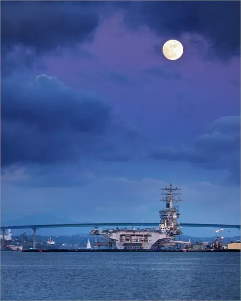 USA, California, San Diego, USS Nimitz moored under full moon in San Diego Bay