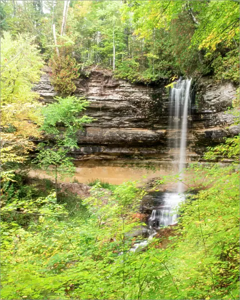 North America, USA, Michigan, Upper Peninsula. Munising Falls framed by hardwood forest in autumn