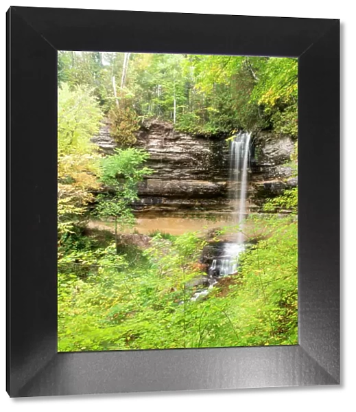 North America, USA, Michigan, Upper Peninsula. Munising Falls framed by hardwood forest in autumn